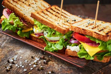 Jambon, marul, peynir ve ahşap zemin ile ev yapımı sandviç