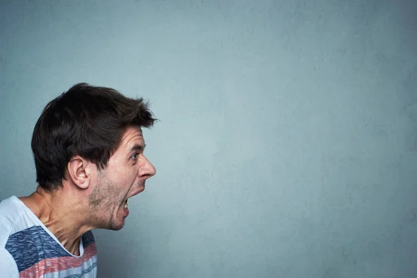 Retrato del hombre gritando en un fondo de pared gris con espacio de copia. Cara gritando — Foto de Stock