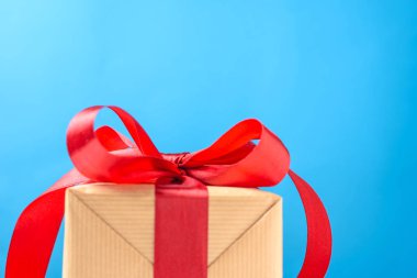 Mavi bir arka plan kopya alanı üzerinde kırmızı fiyonklu hediye kutusu