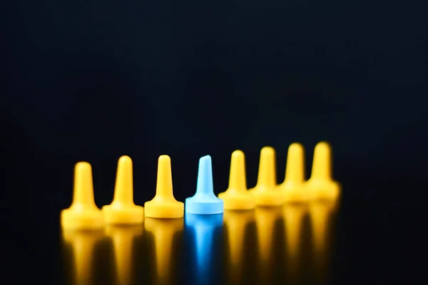 Individualität und Führungskonzept. Blaue Figur hebt sich von gelben Figuren ab — Stockfoto