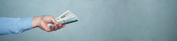 Un uomo mano dando soldi, lungo striscione. Concetto di impresa e investimento — Foto Stock