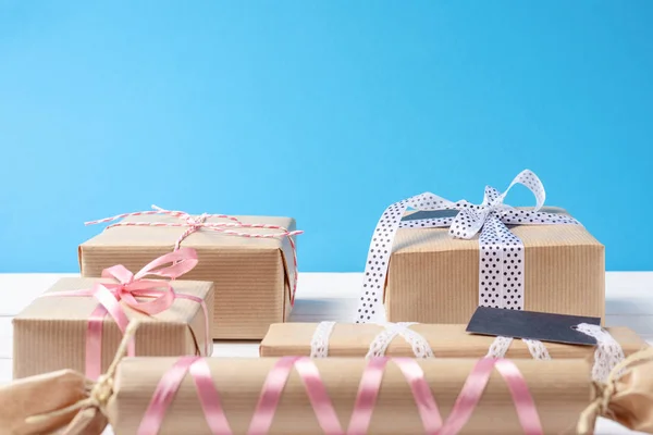 Bir sürü hediye kutuları şerit üzerinde mavi bir arka plan ile yakın çekim — Stok fotoğraf