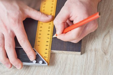 Ahşap tahta, closeup ölçüm alarak marangoz eller