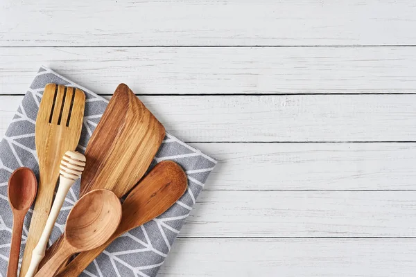 Utensilios de cocina, espátula y toalla sobre fondo de madera blanca con espacio para copiar — Foto de Stock