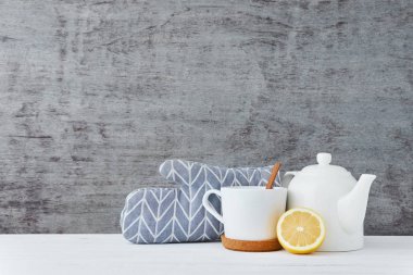 Seramik çaydanlık, beyaz kupa ve limon ahşap arka plan üzerinde