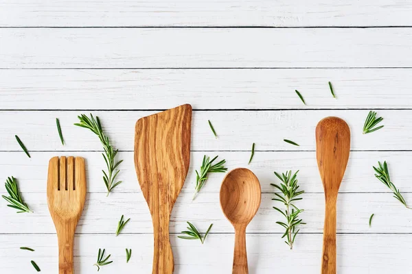 Cubiertos de madera, espátula y cuchara sobre mesa de madera blanca — Foto de Stock