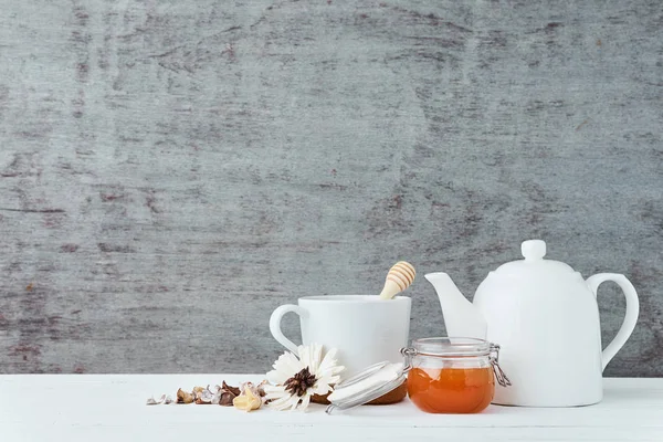 Tetera de cerámica blanca, taza y miel en frasco de vidrio sobre un fondo de madera con espacio para copiar — Foto de Stock