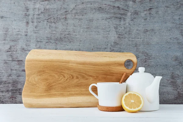 Tetera de cerámica, taza blanca y limón sobre un fondo de madera — Foto de Stock