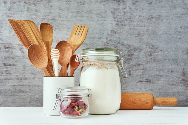 Fondo de utensilios de cocina con cubiertos de madera y rodillo sobre una mesa blanca — Foto de Stock