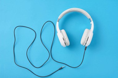 Pastel mavi zemin üzerine beyaz kulaklık