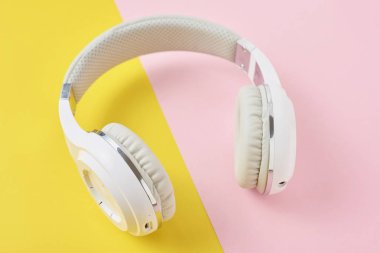 Pembe ve Sarı zemin üzerine beyaz kablosuz kulaklık