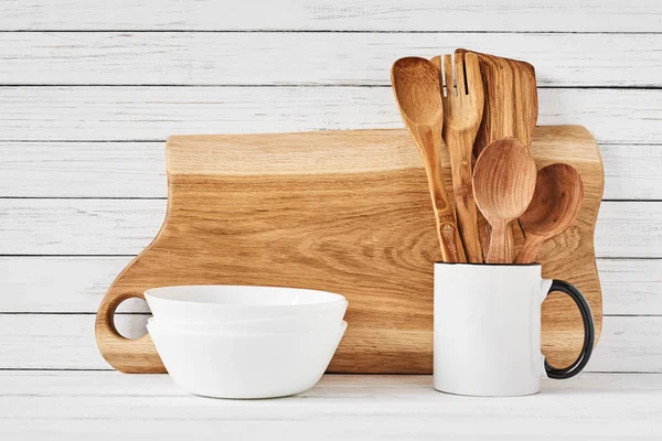 Utensilios de cocina y tabla de cortar sobre mesa blanca — Foto de Stock