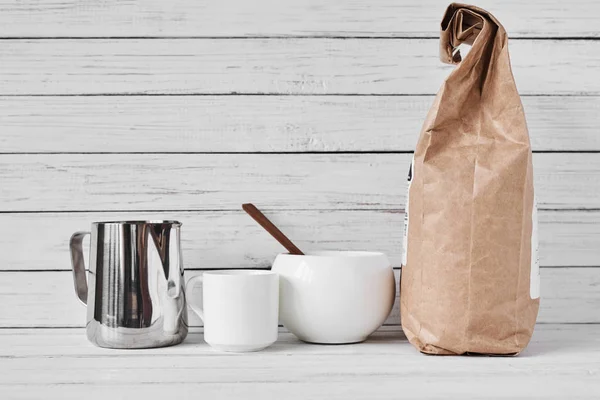 Coffee cup, craft paper bag and stainless pitcher