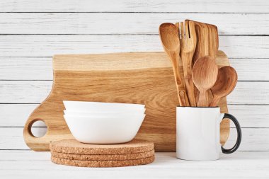 Beyaz masa üzerinde pişirme gereçleri ve kesme tahtası