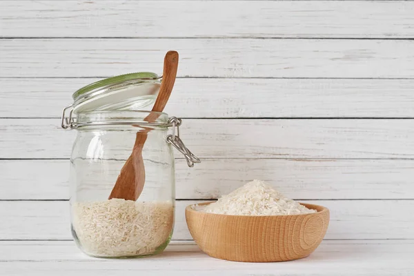 Biji-bijian padi dalam mangkuk kayu dan botol kaca — Stok Foto