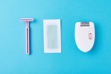 Mavi arka planda epilatör, jilet ve balmumu şeritler