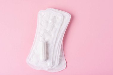 Hijyenik ped ve pembe bir arka plan üzerinde adet tampon