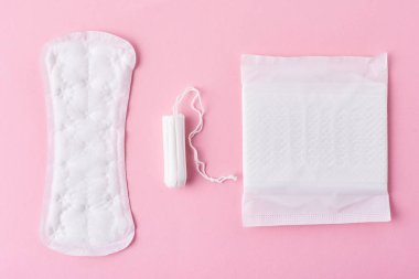 Hijyenik ped ve pembe bir arka plan üzerinde adet tampon