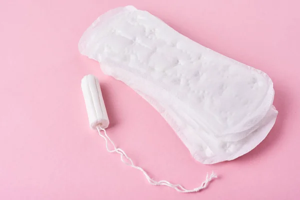 Pad sanitasi dan tampon menstruasi pada latar belakang merah muda — Stok Foto