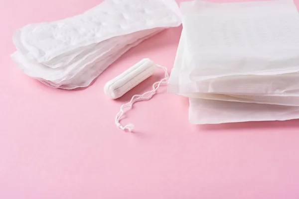 Санитарная прокладка и менструальный тампон на розовом фоне — стоковое фото