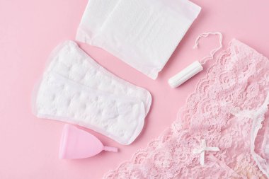 Hijyen Pad, menstrüel fincan, tampon ve külot pembe arka planda