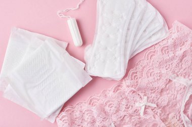 Hijyen Pad, menstrüel fincan, tampon ve külot pembe arka planda