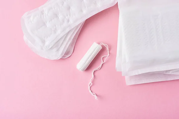 Pad sanitasi dan tampon menstruasi pada latar belakang merah muda — Stok Foto