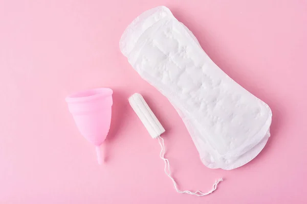 Almohadilla sanitaria, copa menstrual y tampón sobre fondo rosa — Foto de Stock