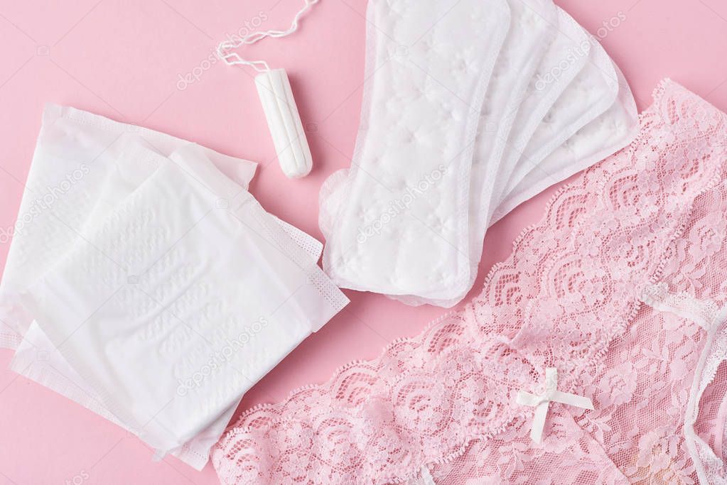 Sanitary pad, menstrual cup, tampon and panties on a pink background