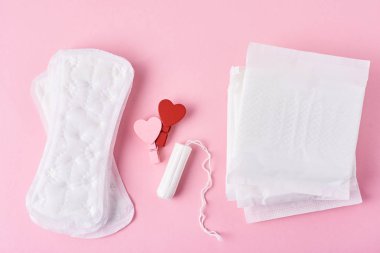 Hijyen Pad, menstrüel tampon ve ahşap kırmızı kalp pembe arka planda, üst görünüm