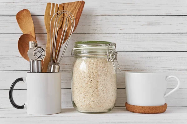 Kitchen tools and glass jar with rice