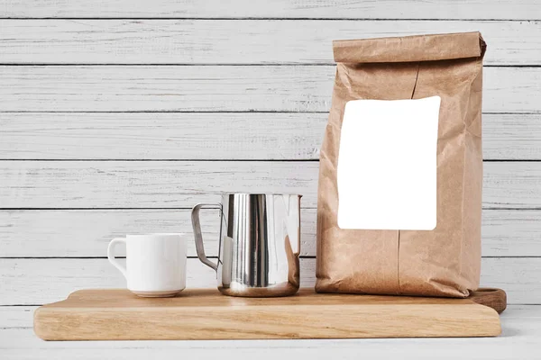 Taza de café, bolsa de papel artesanal y jarra de acero inoxidable — Foto de Stock