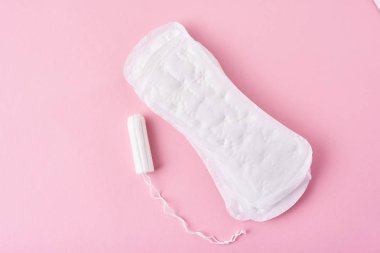 Hijyenik ped ve pembe bir arka plan üzerinde adet tampon
