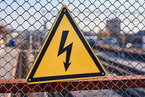 Electrical hazard sign. Lightning on yellow background close up. High voltage electricity on a railway station