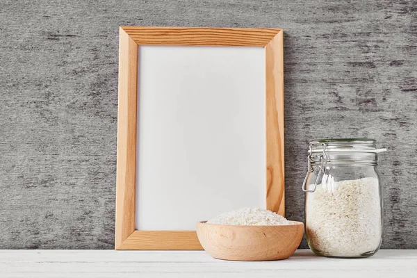 Tarro de vidrio con arroz y cuenco de madera, vista frontal — Foto de Stock