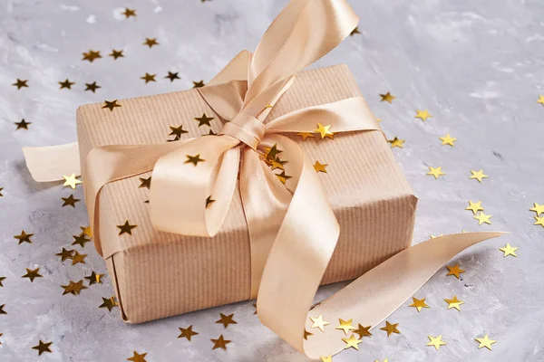 Coffret cadeau avec arc doré et confettis, gros plan — Photo