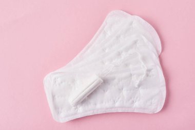 Hijyenik ped ve pembe bir arka plan üzerinde adet tampon