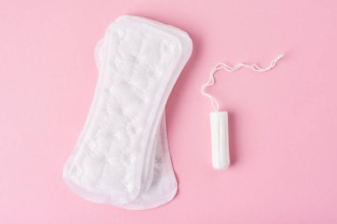 Hijyenik ped ve pembe bir arka plan üzerinde adet tampon