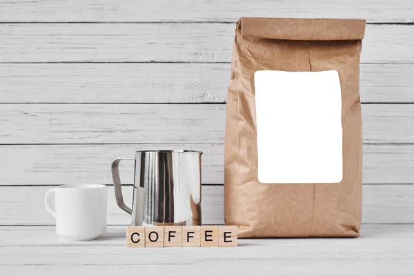 Coffee cup, craft paper bag and stainless pitcher — Stock Photo, Image