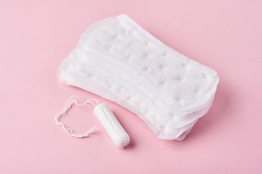 Hijyenik ped ve pembe bir arka plan üzerinde adet tampon