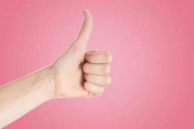 Pembe arka planda olumlu jest. El göster başparmak yukarı işareti,
