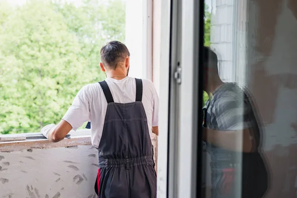 Process male worker repairing window in a house, close up