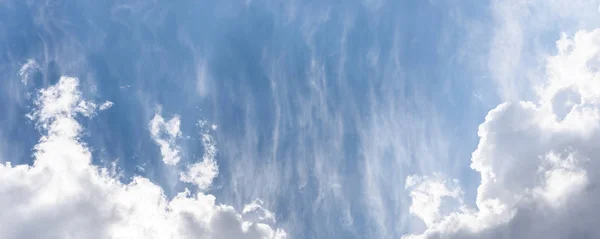 Blauwe lucht achtergrond met een pluizige wolken — Stockfoto