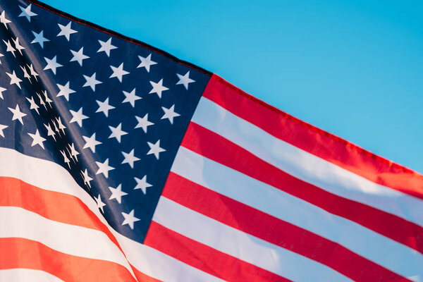 American flag in a blue sky, close up. Symbol of Independence Day fourth of July in USA