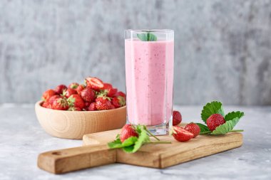 Cam bir kavanozda çilekli süt sallamak ve yaprakları ile taze çilek
