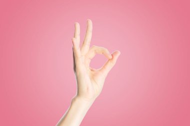 Pembe arka planda olumlu jest. El göster tamam işareti, yakın