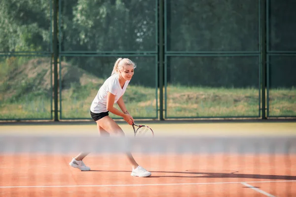 Молода красива жінка грає в теніс на дворі. Здоровий спортивний спосіб життя — стокове фото