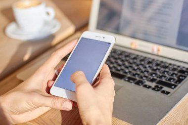 Kadınlar bir kafede kahve molası sırasında akıllı telefon tutun