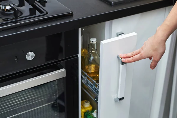Wanita tangan membuka lemari penyimpanan dapur di interior modern — Stok Foto