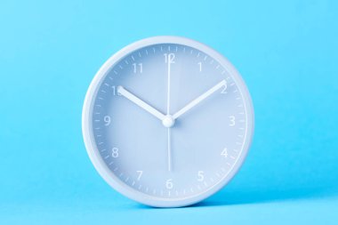 Pastel mavi arka planda gri klasik çalar saat, yakın